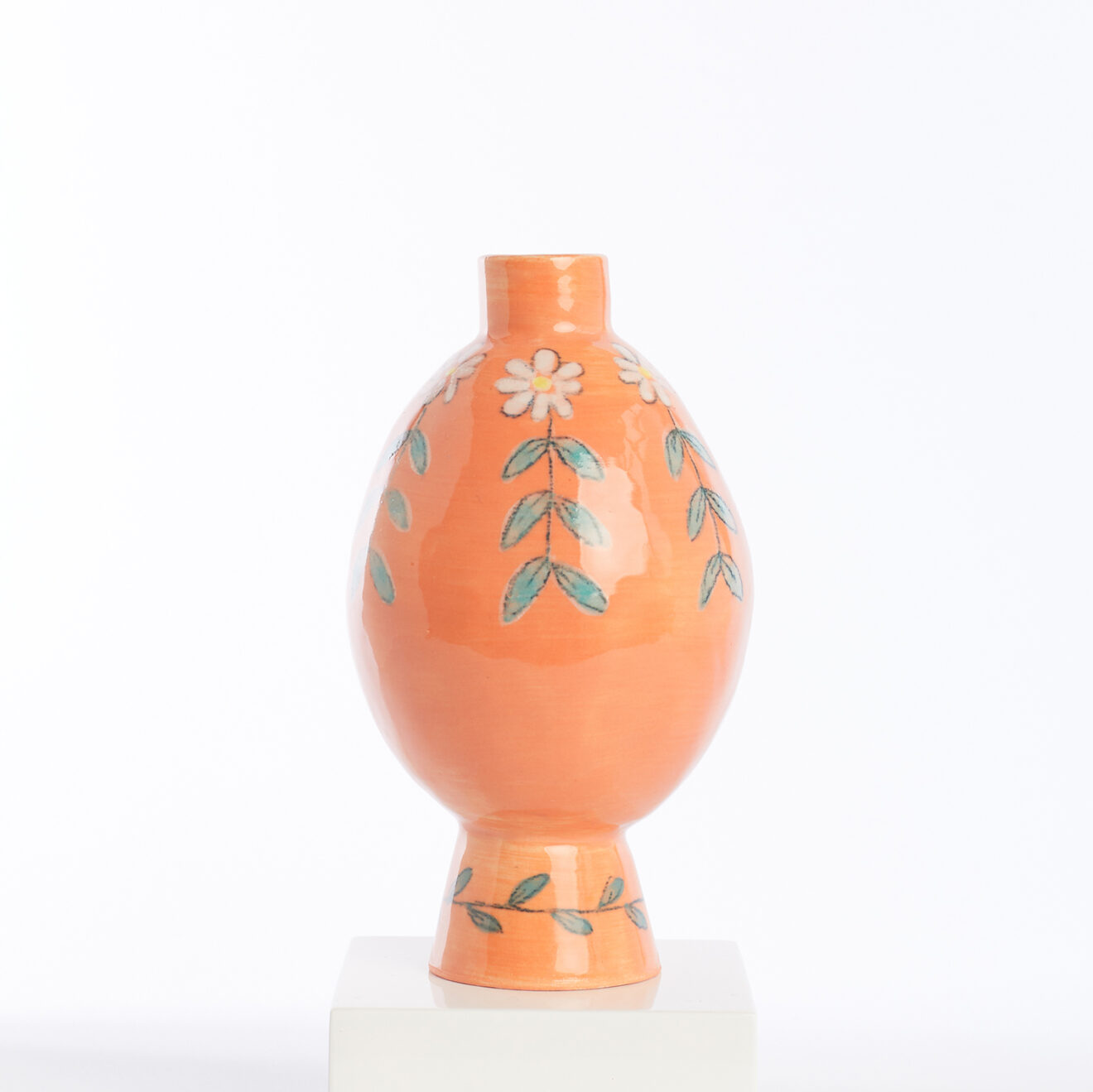 mini orange vase with white flowers and vine leaves Mini orange pot with white flowers and vine leaves